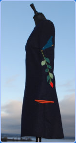 Str M/S Kr 2600,- Mørk blå kjole med dekor av Saave Skaar, en strikket fugle på ermen.